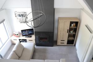 uma sala de estar com um sofá branco e uma lareira em Bulli Beach House em Koksijde
