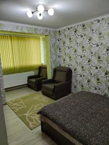 a bedroom with two chairs and a bed in it at Vitalie Lohov in Soroca