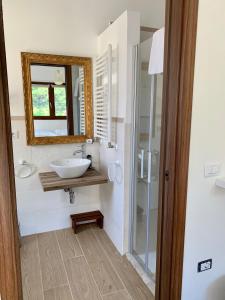 bagno con lavandino, specchio e doccia di Boutique Country House Serendipity a Cantiano