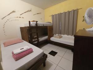 a room with two beds and a desk with a fan at Hostel do Gui in Alto Paraíso de Goiás