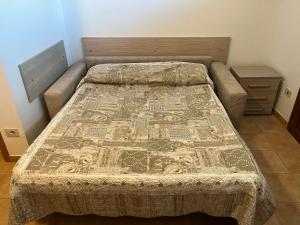 ein Bett mit einer Decke darauf in einem Schlafzimmer in der Unterkunft Holiday House La Rosa in Terricciola