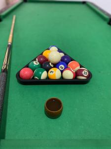 a pool table with billiard balls and a cue at Sun shine chalet in Al Ḩadd