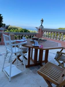 une table et des chaises en bois assises sur un balcon dans l'établissement Chambre d'hôtes A l'ancre marine, à Nice