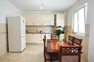 een keuken met een tafel en een witte koelkast bij Petra flat apartment in Bar