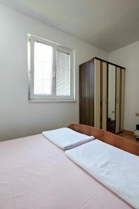 biała sypialnia z 2 łóżkami i oknem w obiekcie Petra flat apartment w Barze