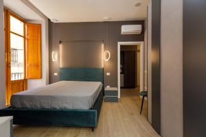 a bedroom with a bed and two lights on the wall at Seven Winds Suite in Naples
