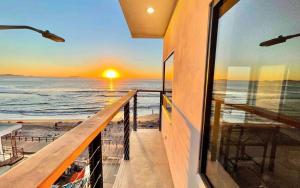 un balcón con vistas al océano al atardecer en Lovely Beach 1-Bed unit in Playas de Tijuana, en Tijuana