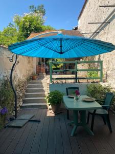 a blue umbrella on a deck with a table and chairs at La Passerelle de Crécy in Crécy-la-Chapelle
