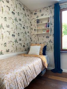 a bedroom with a bed with floral wallpaper at La Passerelle de Crécy in Crécy-la-Chapelle