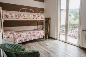 ein Schlafzimmer mit einem Etagenbett und einem Stuhl sowie einem Balkon in der Unterkunft House Of Alex in Levanto