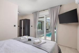 a bedroom with a bed with towels on it at Villa La Vie in Garica
