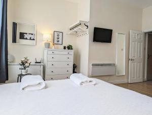 a white bedroom with a white bed and a tv at Guest Rooms In Anfiled Near Stadium, Free Parking in Liverpool