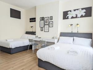 a bedroom with two beds and a desk in it at Guest Rooms In Anfiled Near Stadium, Free Parking in Liverpool