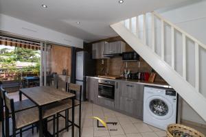 a kitchen and dining room with a table and a washing machine at Cozy duplexterrace barbecue pool beach on foot in Le Pradet