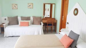 a bedroom with two beds and a desk and a mirror at Habitaciones Ninfa in Villalonga