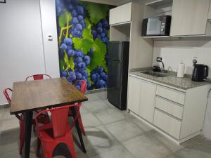 a kitchen with a table and a refrigerator at 787 Suites in La Cieneguita