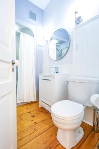 La salle de bains blanche est pourvue de toilettes et d'un miroir. dans l'établissement Mahone Bay Bed and Breakfast, à Mahone Bay
