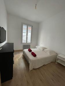 1 dormitorio con 1 cama con 2 almohadas rojas en Cosy nid douillet au cœur du centre ville de Perpignan, en Perpiñán