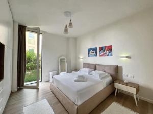 a bedroom with a large white bed and a window at 3E_Apartment_Palase / Villa 149/2 in Palasë