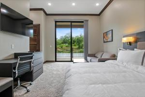 ein Hotelzimmer mit einem Bett, einem Schreibtisch und einem TV in der Unterkunft The Resort at Lake of the Ozarks in Lake Ozark