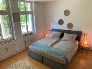 a bedroom with a bed with two pillows and two windows at Ferienwohnung Parkblick - Balkon 77m2 in Bad Rothenfelde
