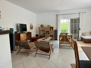 uma sala de estar com um sofá, uma mesa e cadeiras em Villa Vilamar em Porches