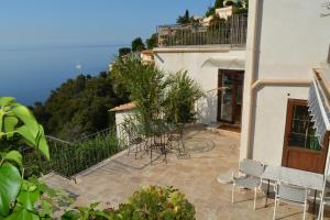 uma varanda de um edifício com mesas e cadeiras em Petit coin de Paradis a cote de Monaco em Roquebrune-Cap-Martin