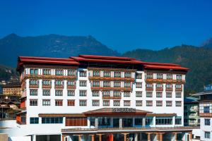 Le Meridien Thimphu في تيمفو: مبنى ابيض كبير بسقف احمر