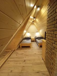 um quarto no sótão com 2 camas e uma parede de tijolos em Domek Szarotka em Zakopane