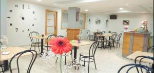 un restaurante con mesas y sillas y una flor roja en Habitaciones Ninfa, en Villalonga