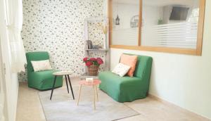 ein Wohnzimmer mit 2 grünen Stühlen und einem Tisch in der Unterkunft Habitaciones Ninfa in Villalonga