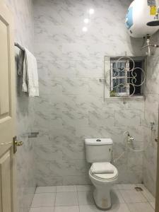 a white bathroom with a toilet and a window at Luxury 2 bed apartment. 