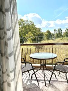 eine Terrasse mit einem Tisch und Stühlen auf dem Balkon in der Unterkunft Sunshine Apartment in Preveza