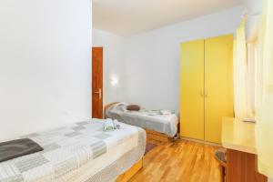 - une chambre avec 2 lits et une armoire jaune dans l'établissement Apartments Lora, à Pula