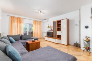 - un salon avec un canapé et une télévision dans l'établissement Apartments Lora, à Pula