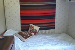 ein kleines Bett mit zwei Kissen darüber in der Unterkunft Villa Vintage in Tammela