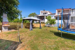 une arrière-cour avec une table et un parasol dans l'établissement Apartments Lora, à Pula