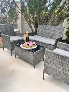 a patio with wicker chairs and a table with a bottle of champagne at Villa M.COCO in Pula
