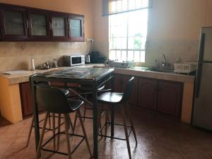 a kitchen with a black table and stools in it at Bel appartement avec piscine dans résidence privée in Cap Malheureux