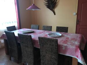 勒拉芒丹的住宿－Bel appartement avec piscine dans résidence privée，餐桌、椅子和粉红色的桌布