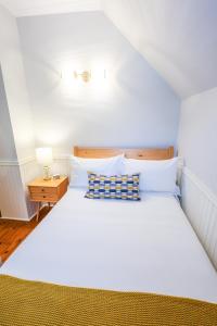 1 dormitorio con 1 cama blanca grande y mesita de noche en Mahone Bay Bed and Breakfast, en Mahone Bay