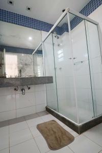 a shower stall in a bathroom with a rug at Casa da Manu Búzios in Búzios