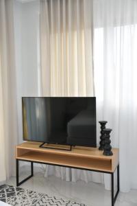 a flat screen tv sitting on top of a wooden table at URBAN SUITES ATHENS in Athens