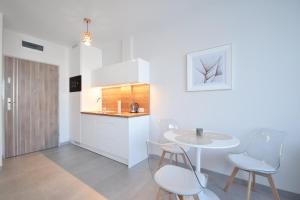een keuken met een tafel en stoelen in een kamer bij Apartamenty Ada 2 Resort Klifowa Rewal in Rewal