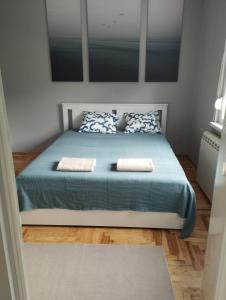 a bedroom with a blue bed with two pillows at Apartman Aleksandra in Smederevo
