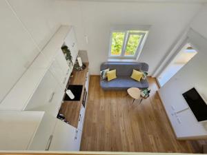 ein Wohnzimmer im Dachgeschoss mit einem blauen Sofa und einem Fenster in der Unterkunft Holiday Apartment Deluxe in Savudrija