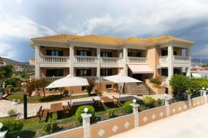 un gran edificio con sombrillas delante en Lady Elena Hotel en Ammoudia