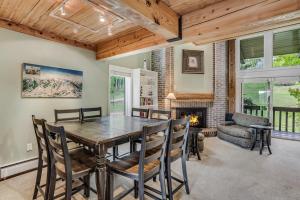 a dining room with a table and chairs and a fireplace at Interlude Condominiums 3-Bedroom Unit 307 in Snowmass Village