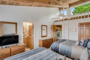 a bedroom with two beds and a flat screen tv at Interlude Condominiums 3-Bedroom Unit 307 in Snowmass Village