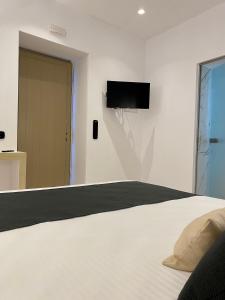 a bedroom with a bed and a tv on the wall at Asteras Cozy Stay in Naousa